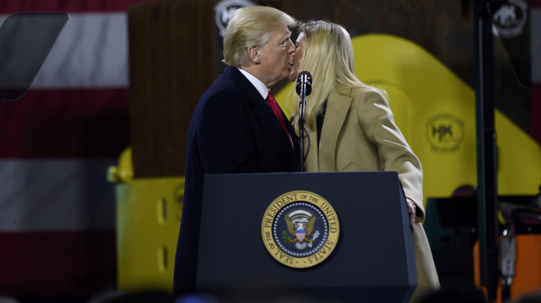 Donald Trump and Ivanka Trump kissing with open mouths behind a lectern at H&K Equipment in 2018.