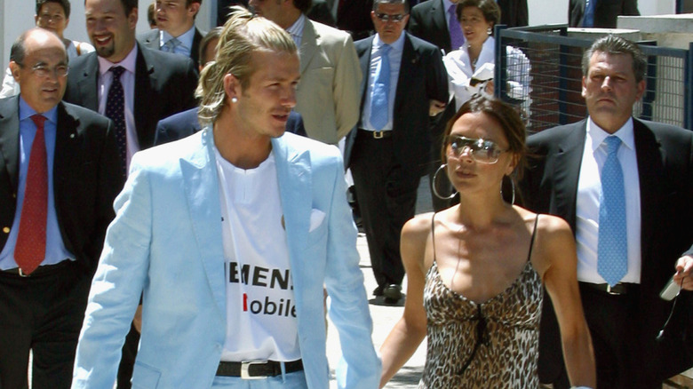 David and Victoria Beckham walk through a crowd of people in Madrid