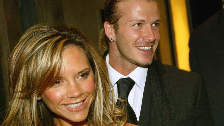 Victoria and David Beckham smile as they closely embrace