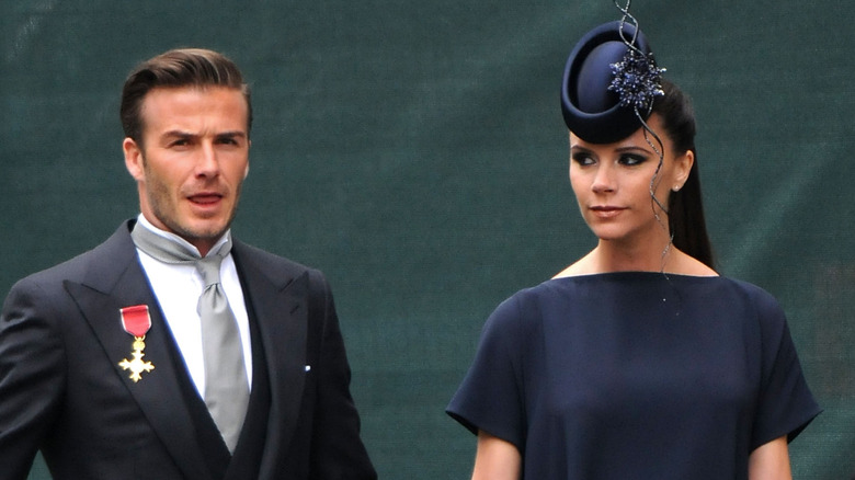 David and Victoria Beckham arrive at a wedding in formal clothing