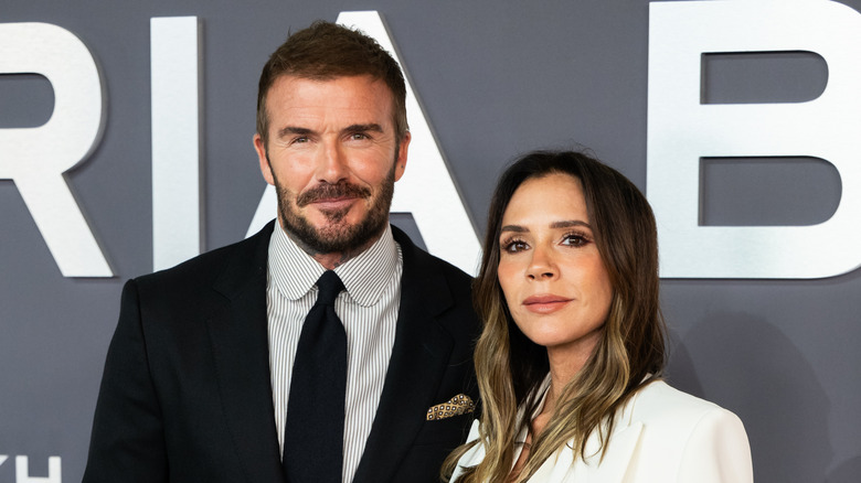 David and Victoria Beckham smile at the camera at a red carpet event