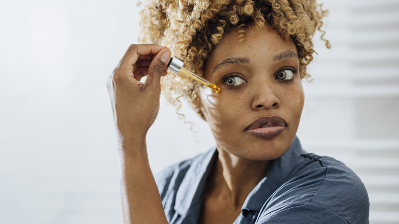 Woman putting serum on skin