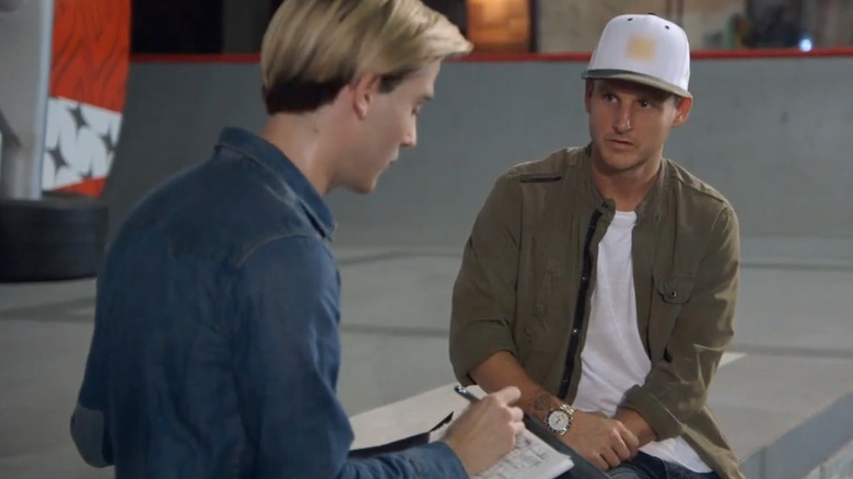 Tyler Henry sitting with skater Rob Dyrdek