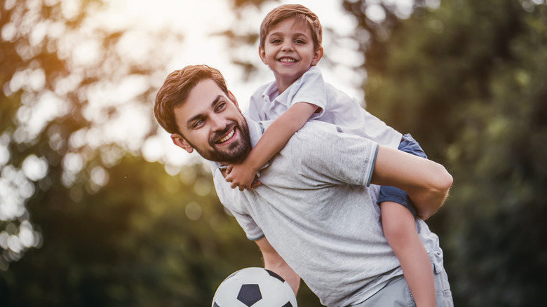 Father and child playing soccer