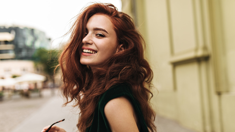 Smiling white woman with red-tinted brown hair