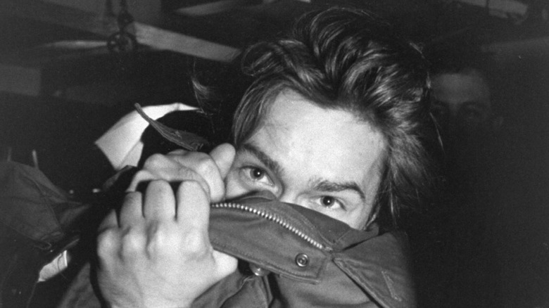 River Phoenix using his jacket to cover his face from the bride of the nose down