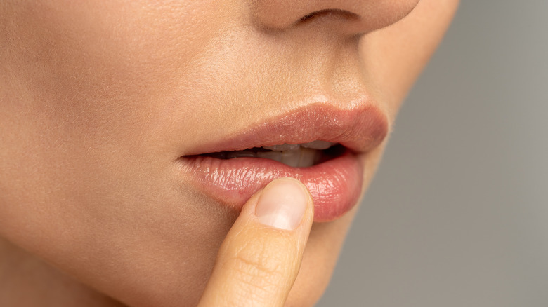 Woman applying Vaseline to lips
