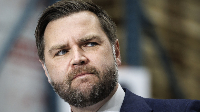 JD Vance looking sideways while frowning in a suit