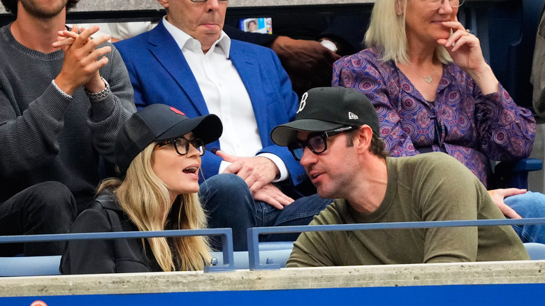 Emily Blunt and John Krasinski wearing ball caps and glasses at the US Open