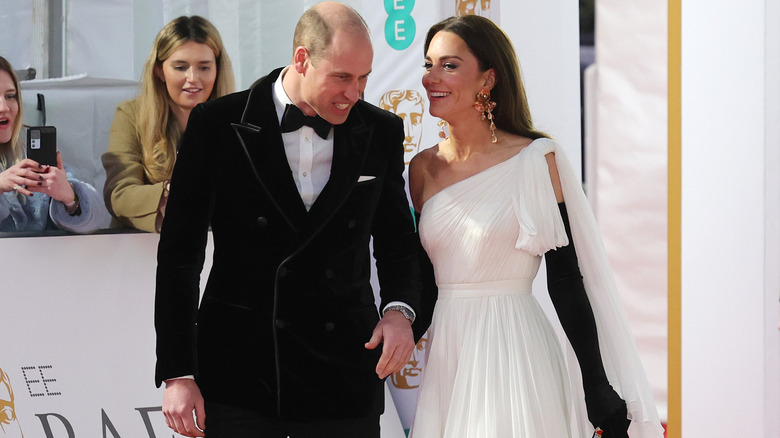 Princess Catherine whispering to Prince William on the red carpet during the 2023 BAFTA Awards