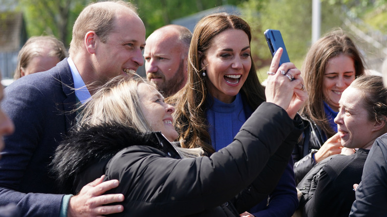 Prince William and Princess Catherine posing for a selfie with a fan