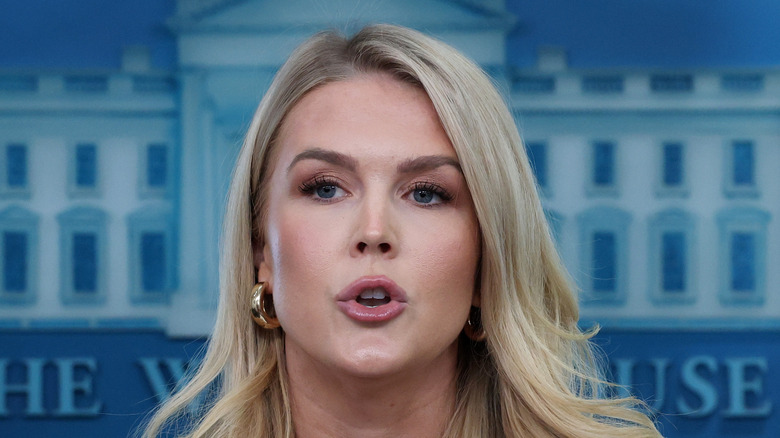 Karoline Leavitt speaking at a press briefing while wearing a green blazer.