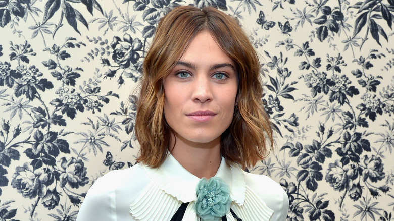 Alexa Chung by a flowered wall