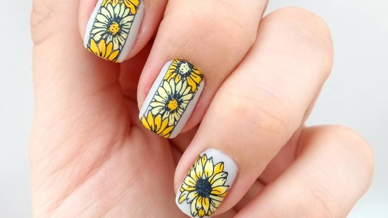 Close-up of nails with sunflower nail art