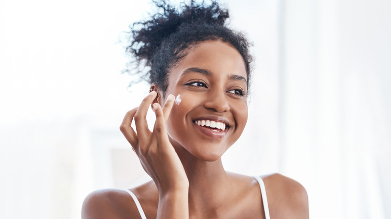 Woman applying moisturizer