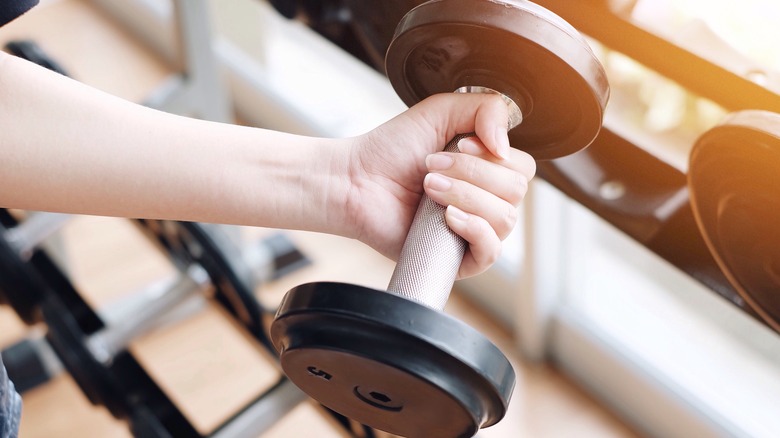 Woman's hand lifting dumbbell weight