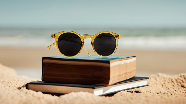 sunglasses on books on the beach