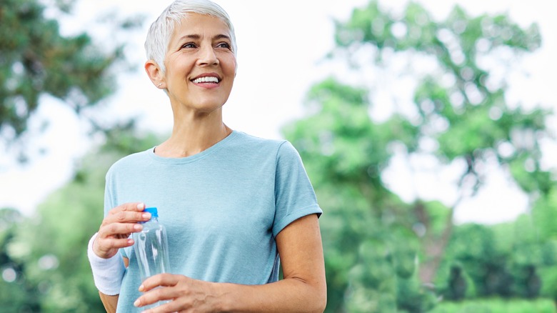 older woman holding water bottle