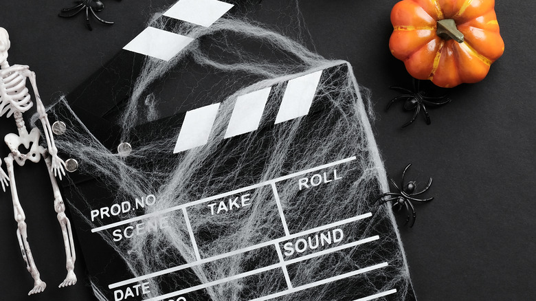 Film take with spiders, spider webs, pumpkins and skeleton
