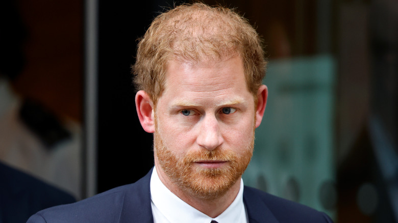 Closeup of Prince Harry wearing a suit and looking sad