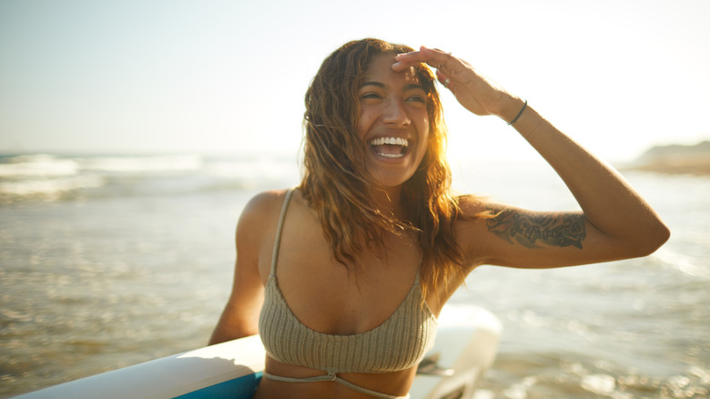 Woman with surfboard on beach