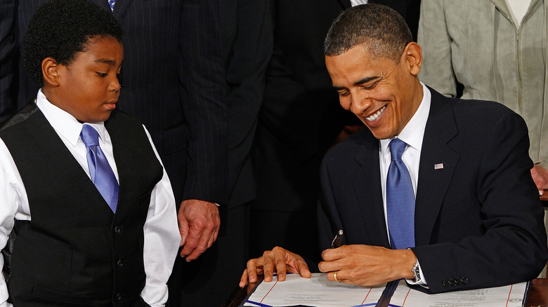 Barack Obama signs the Affordable Health Care for America Act.
