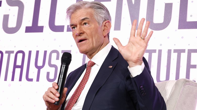 Dr. Oz hand up holding mike