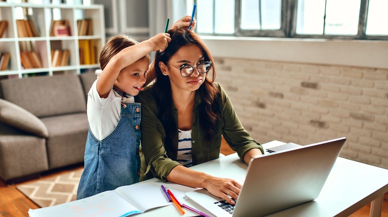 Mom tries to work at home with her daughter