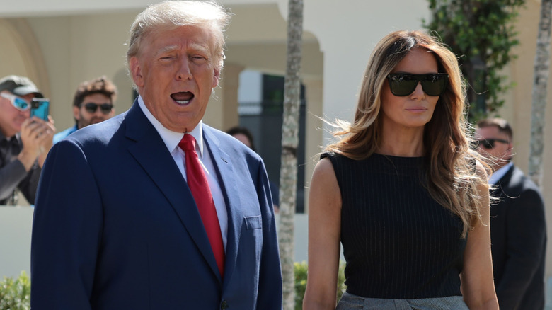 Donald Trump saying something as Melania Trump looks grim