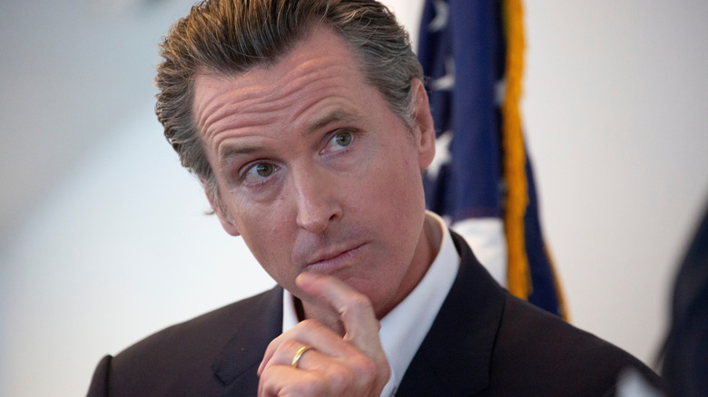 Gavin Newsom looking deep in thought with a finger to his chin