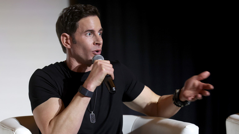 Tarek El Moussa speaking at an event in a black T-shirt