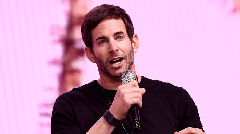 Tarek El Moussa speaking at an event in a black T-shirt