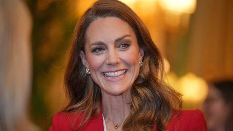 Princess Catherine smiling in a red blazer