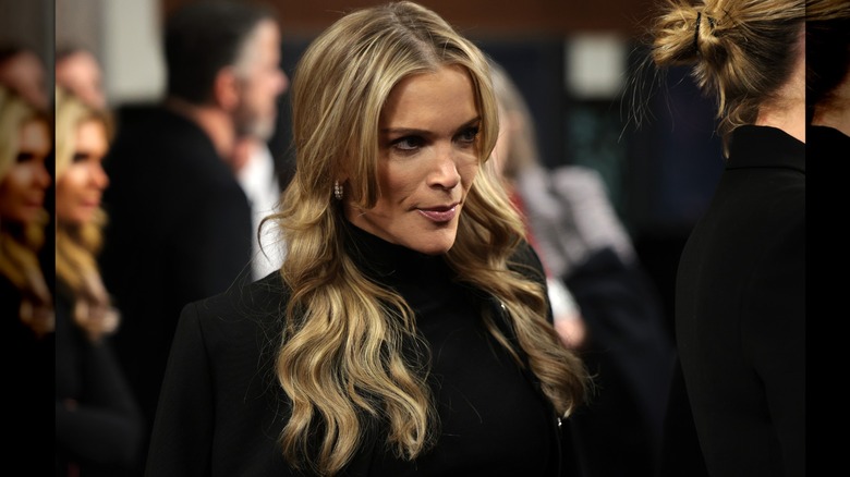 Megyn Kelly dressed in a black roll neck sweater looking angry