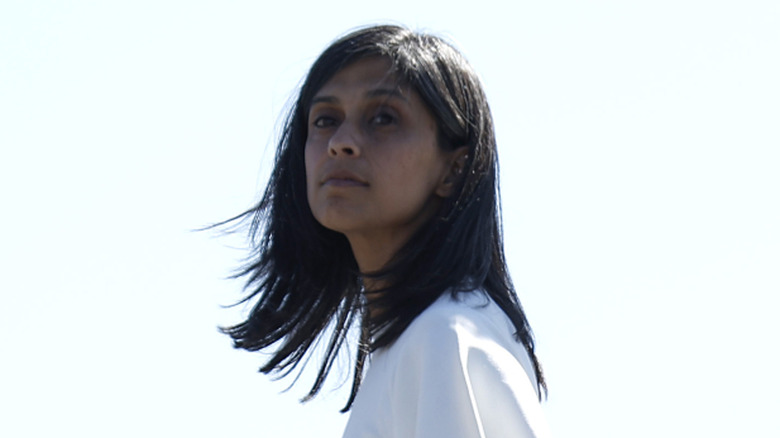 Usha Vance walking down an airplane ramp while wearing a white dress.