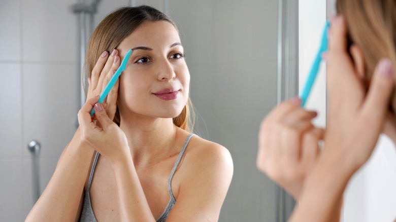 Woman using facial razor