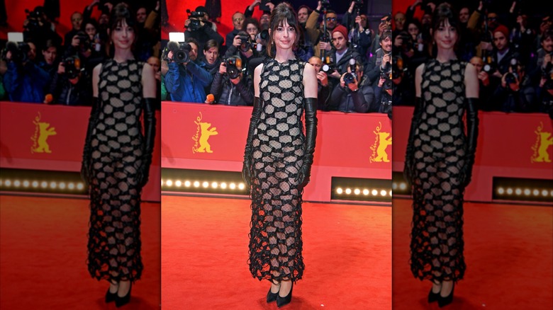 Anne Hathaway posing in a black dress and high-heels at the premiere of "She Came to Me" on the Berlin red carpet.