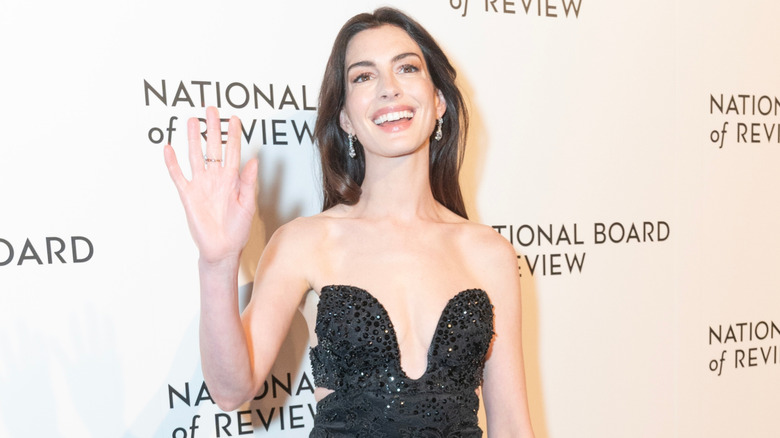 Anne Hathaway smiling in a black dress at the National Board of Review awards gala.