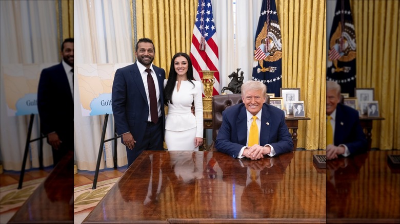 Kash Patel stands with his arm around Alexis Wilkins posing beside a seated Donald Trump.