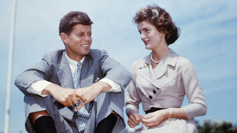 Jackie and John F. Kennedy sitting on the grass
