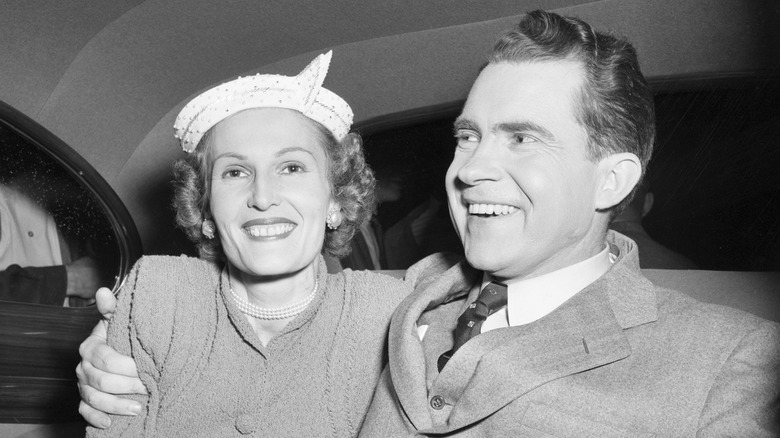 Pat and Richard Nixon smiling in a car