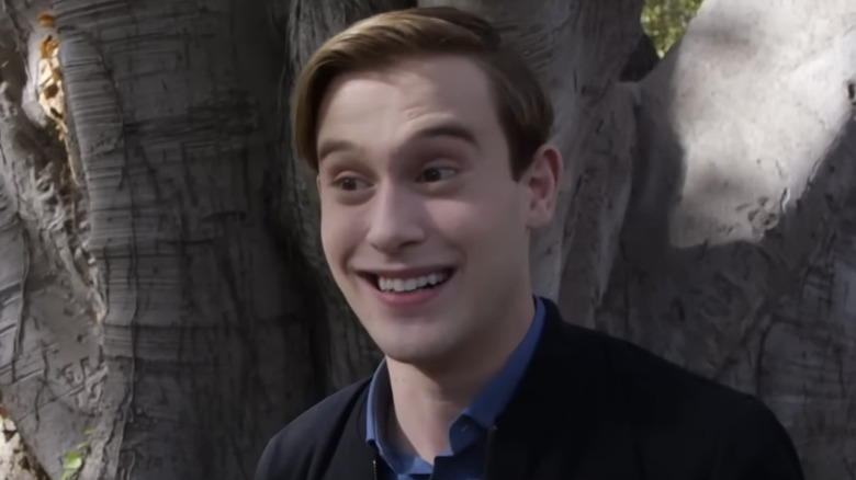 Tyler Henry smiling while standing in front of tree outside