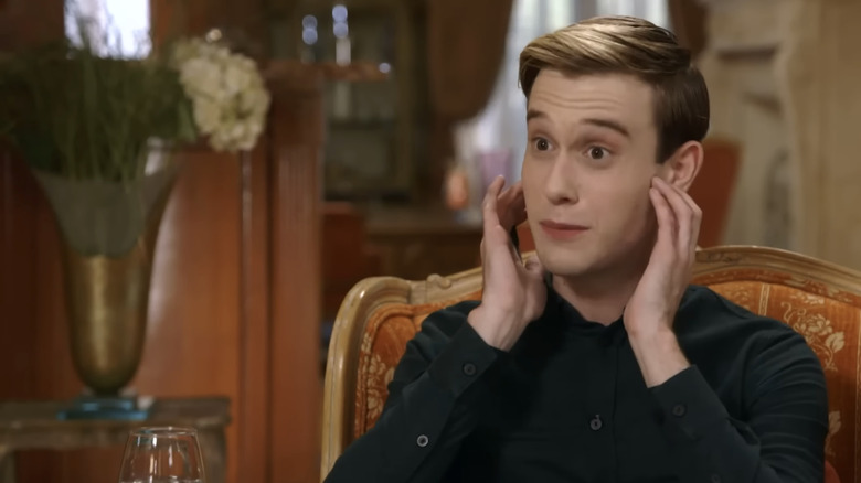 Tyler Henry doing a reading while seated in orange chair
