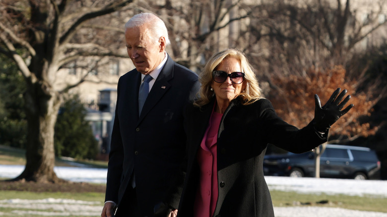 Jill Biden waving at onlookers as she walks alongside Joe Biden