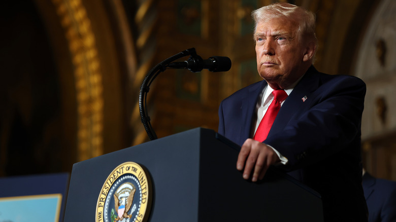 Donald Trump looking serious behind a podium