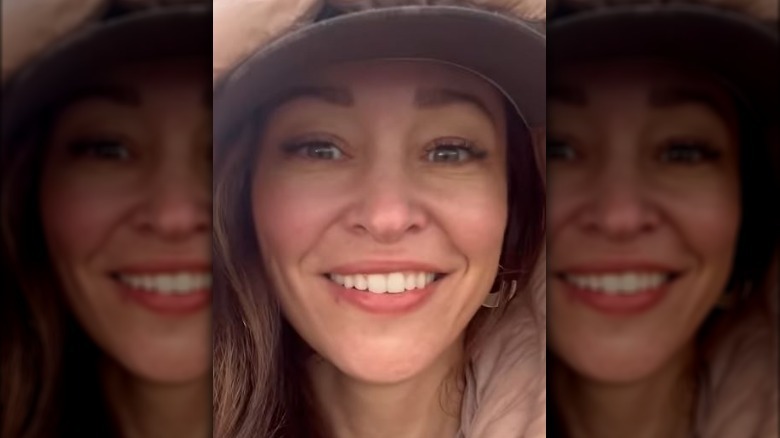 Autumn Reeser in a pink coat and baseball cap