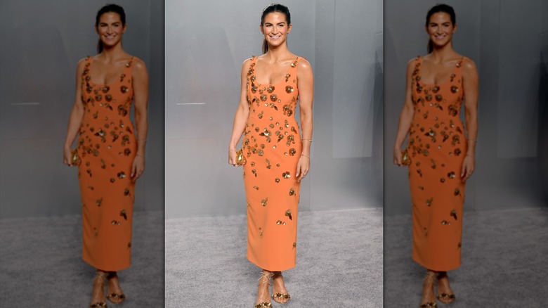 Kailtan Collins posing in a bright orange, embellished dress at the 2026 Vanity Fair Oscars Afterparty