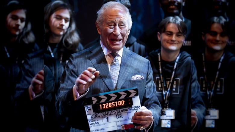 King Charles III smiling with clapboard