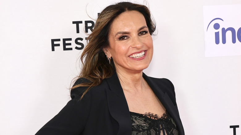 Mariska Hargitay smiling big in front of a white background.