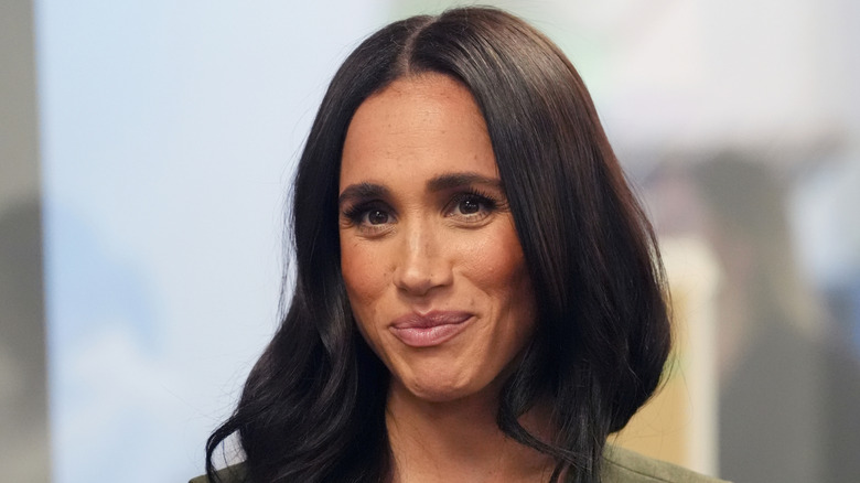Meghan Markle close up in green sleeveless dress